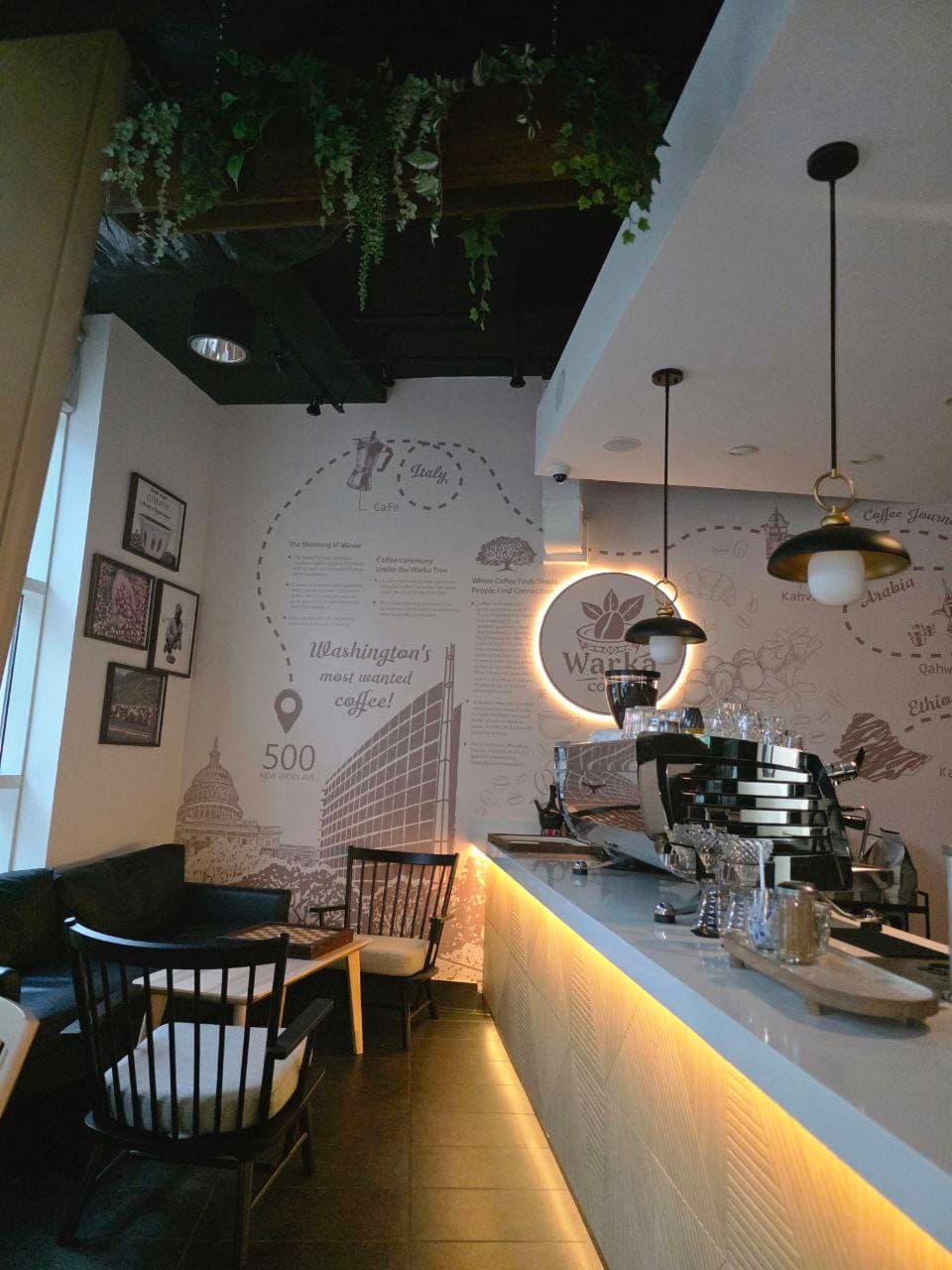 Warka Coffee café interior with warm amber lighting and botanical wall murals