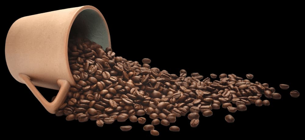 Roasted coffee beans spilling from a kraft cup